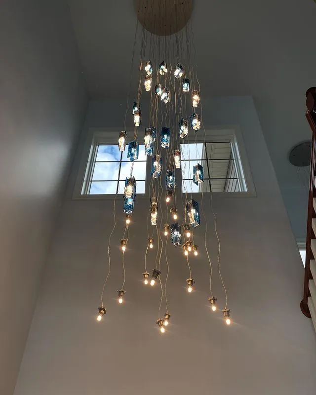 Cascading glass pendant chandelier hung in a two-story great room