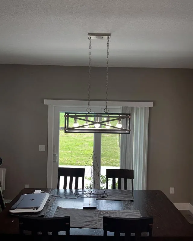 Linear dining fixture over a table by patio doors
