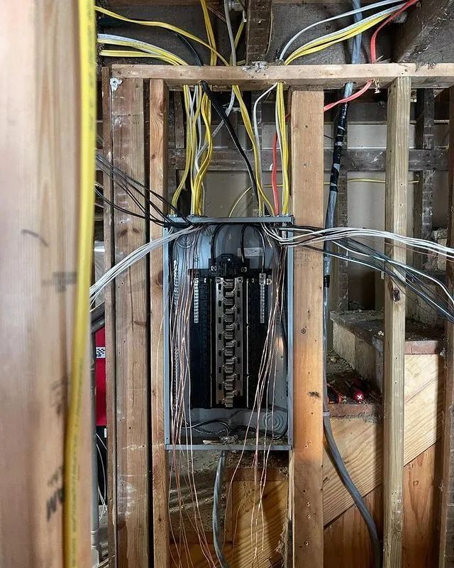 Rough-in wiring feeding a new panel inside an open wall