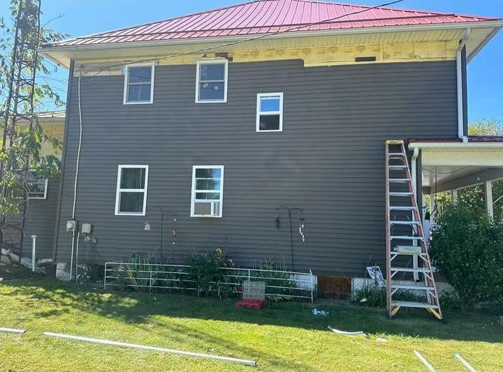 Ladder set against a house during an exterior service change