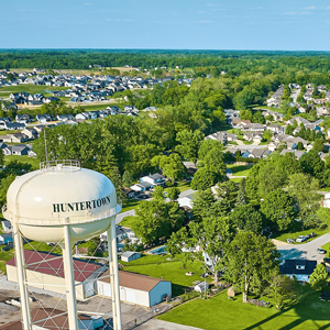 A water tower labeled "Huntertown" stands over a suburban residential area with houses, trees, and roads visible—ideal for those seeking reliable electrical services or expert electrician service in Angola.