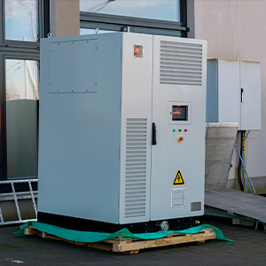 A large industrial electrical cabinet, branded with About All Wire Electric, sits on a wooden pallet outside a building, its warning and control panels clearly visible on the front.